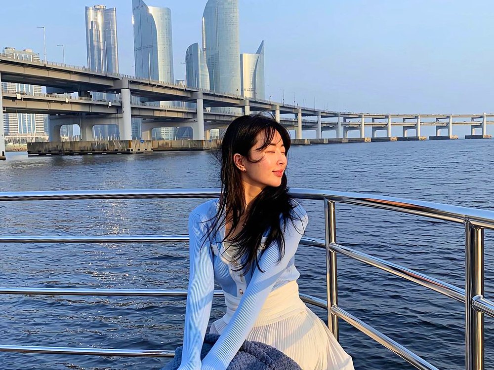 광안대교와 마린시티를 배경으로 크루즈 난간에 앉은 손님