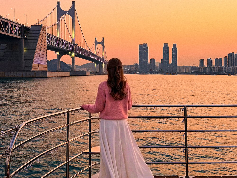 노을 진 광안대교를 바라보는 크루즈 위의 손님